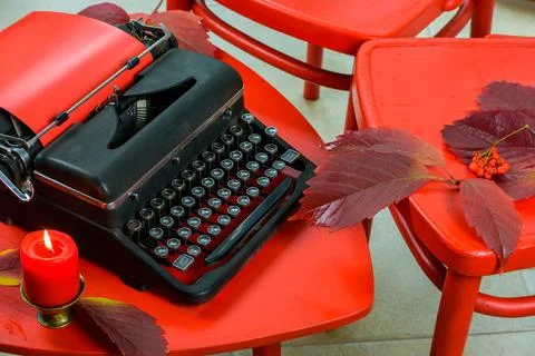 Old typewriter on a red table with red chairs Stock Photos