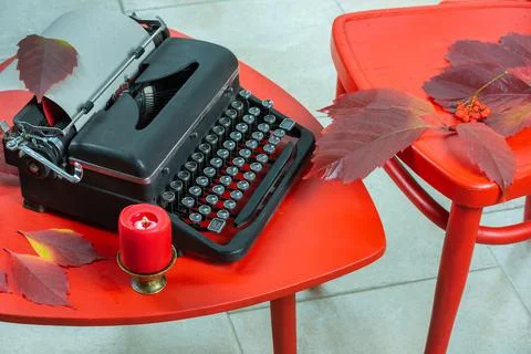 Old typewriter on a red table with red chairs Stock Photos