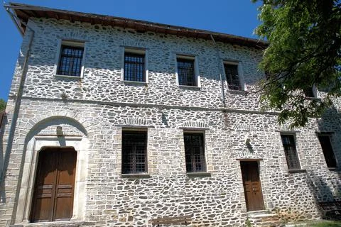 Old typical stone building under a blue sky and sunlight in Greece Fotos de archivo
