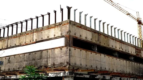 The old unfinished building on the background of sky and crane. the site isn't Stock Footage 92086503