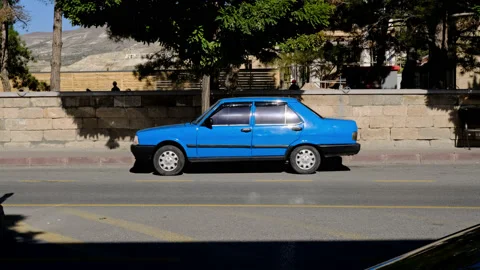 Old unrecognizable blue car stands on street. bright blue retro car is parked Stock Footage 165569512