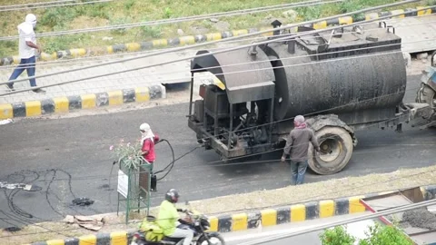 Old unsafe road construction methods used in India. Man pouring tar. Vídeos de archivo 155583608