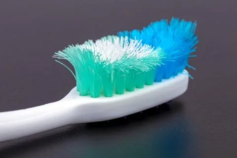 Old unusable worn-out close up toothbrush on black background Stock Photos