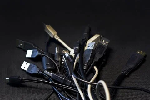 Old USB plug cable isolated on black background. Stock Photos