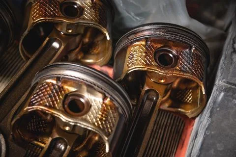 Old used engine pistons close up. Four pistons from an old disassembled engine Stock Photos
