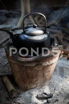 Old used kettle on tradition stove with water stream Stock Photos