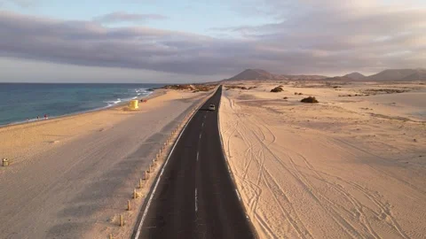 Old van driving in Corralejo desert road. Aerial low angle shot at sunset. Stock Footage 346823668