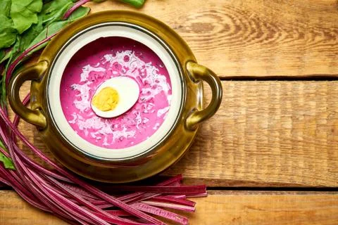Old vase with cold beetroot soup with egg on rustic wooden table Stock Photos