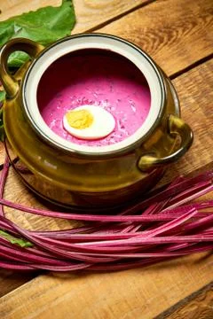 Old vase with cold beetroot soup with egg on rustic wooden table Stock Photos