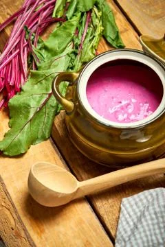 Old vase with  cold beetroot soup and spoon on rustic wooden table Stock Photos