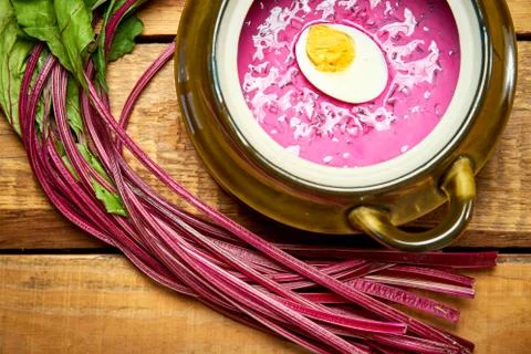 Old vase with cold beetroot soup with egg on rustic wooden table Stock Photos