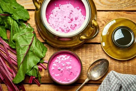 Old vase with  cold beetroot soup and spoon on rustic wooden table Stock Photos