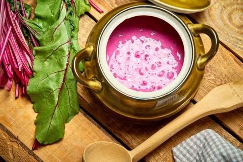 Old vase with  cold beetroot soup and spoon on rustic wooden table Stock Photos