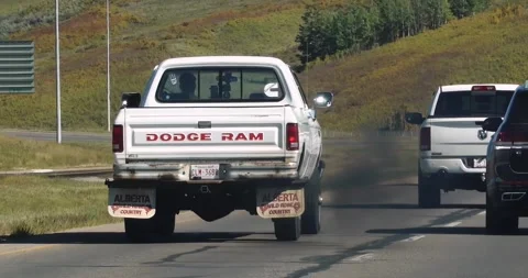 An old vintage Dodge RAM truck, traveling along the road, emitting black smoke Stock Footage 250431253