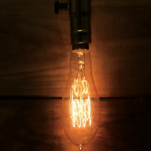 Old vintage Edison's light bulb gradually defocused and transformed into bokeh. Stock Footage 69348959