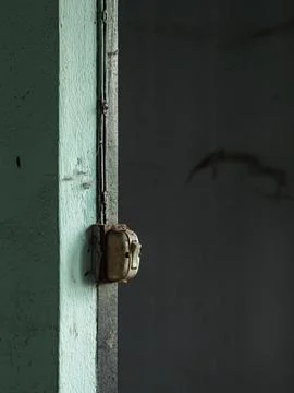 Old vintage electrical light switch mounted on turquoise green plaster wall.. Stock Photos