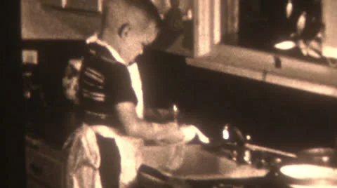 Old Vintage Film 1940s Little Boy Washes Dishes Sink Kitchen Chores Black White Vídeos de archivo 25911278