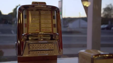 Old vintage jukebox machine playing music in retro 50s shop with cars drivin Stock Footage 241940924