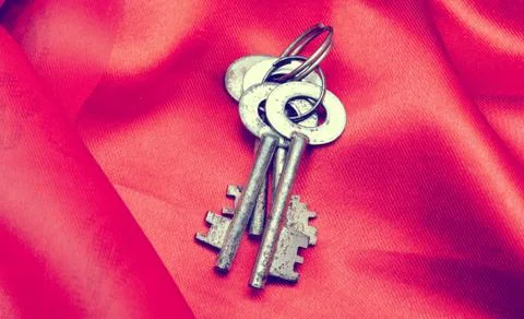 Old vintage keys on red fabric Stock Photos
