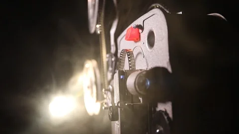 Old vintage movie projector on a dark background with fog and light Stock Footage 105964245