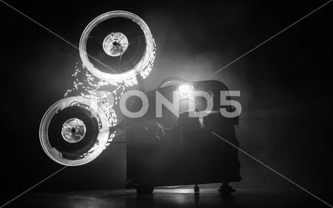 Old vintage movie projector on a dark background with fog and light. Concept Stock Photos