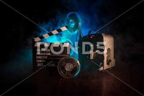 Old vintage movie projector on a dark background with fog and light. Concept Stock Photos