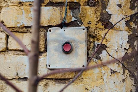 Old, vintage red button on the brick wall Stock Photos
