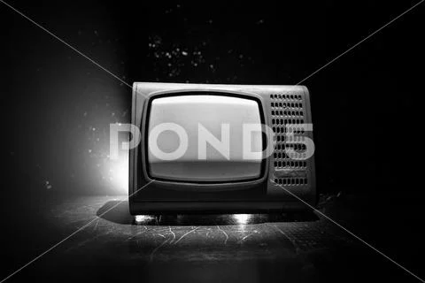 Old vintage red TV with white noise on dark toned foggy background. Retro old Stock-Fotos