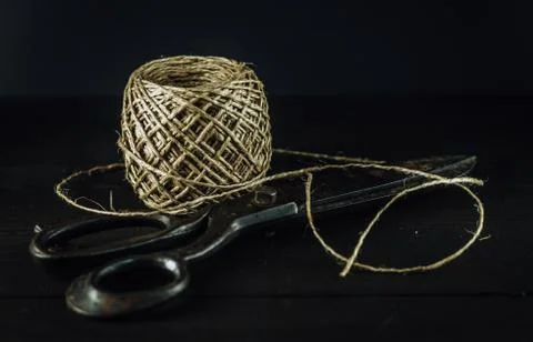 Old vintage rusty scissors with thread yarn twine ball on the table. 写真素材
