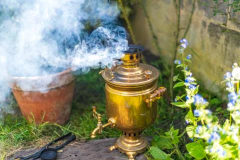 Old vintage samovar with smoke. Brewing tea in the old fashioned way. Russian Stock Photos