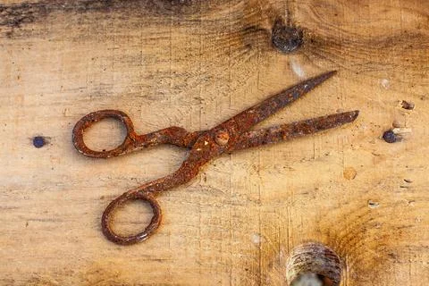 Old vintage scissors covered in rust on wooden board Stock Photos