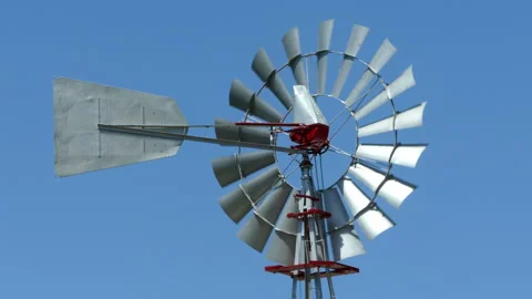 Old vintage style windmill rotating on a sunny day with blue sky background. Stock Footage 108508121