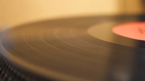 Old vinyl is playing on a silver record player. Yellow background, closeup view Stock Footage 111441478