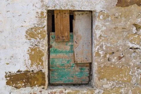 Old wall with a bricked window shuttered with old wood for background. Stock Photos
