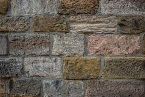 Old wall of a historical building with different colored stones 库存照片