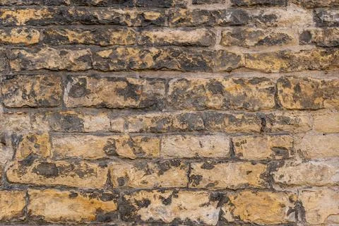 Old wall made of beige irregular stone 写真素材