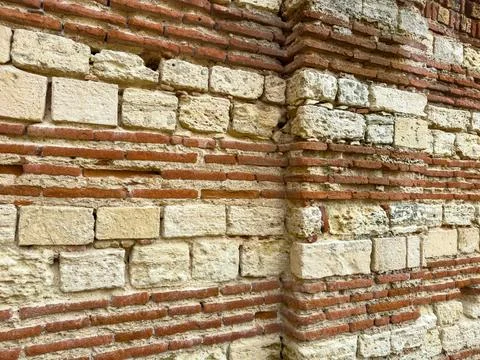 Old wall made of bricks and stones showing signs of wear and age in a histo.. Stock Photos