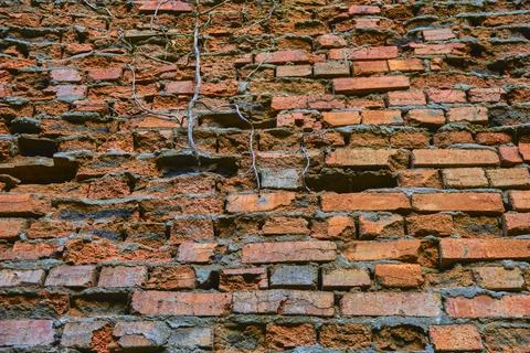 Old wall made of broken red brick Stock Photos