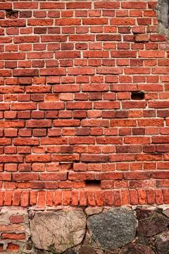 An old wall made of red bricks and stones Stock Photos