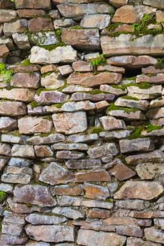 Old wall masonry of different sizes with moss Foto stock