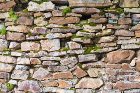 Old wall masonry of different sizes with moss Stock Photos