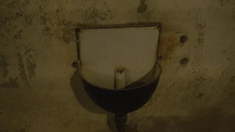 An old, wall-mounted basin with a rusted metal frame and a white, hinged cover. 스톡 동영상 301037431