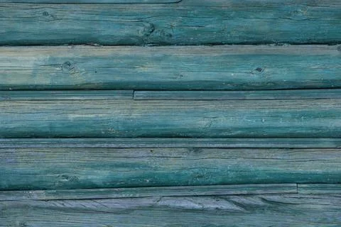 An old wall of pine logs. Weathered, faded wood. Green paint faded in the s.. Stock Photos