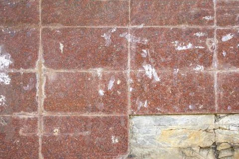 Old wall of rectangular red tiles with stains of paint and dirt and broken ti Foto stock