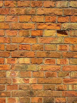Old wall with scratched bricks close-up. Stock Photos
