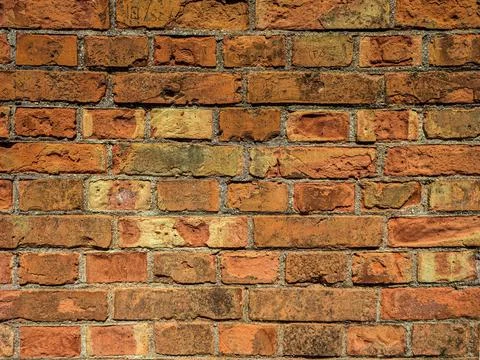 Old wall with scratched bricks close-up. Stock Photos