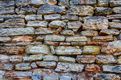 An old wall of stone. Old masonry. The stone is in the wall. stone fence. Stock Photos