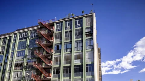Old warehouse building with fire escape stairs in baercelona Stock Footage 317940943