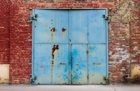 Old warehouse rusty entry with aged red brick wall texture may be used for gr Stock Photos
