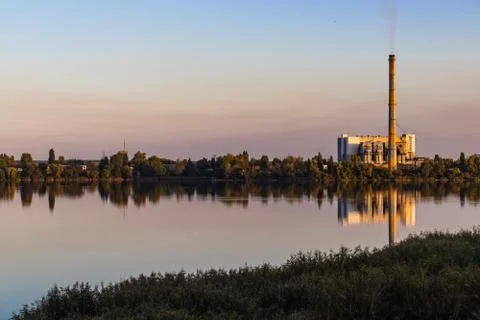 Old waste processing plant at the lake. Sunset Stock Photos